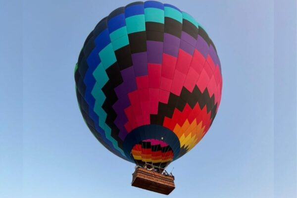 Imagem de balão colorido sobrevoando o céu azul